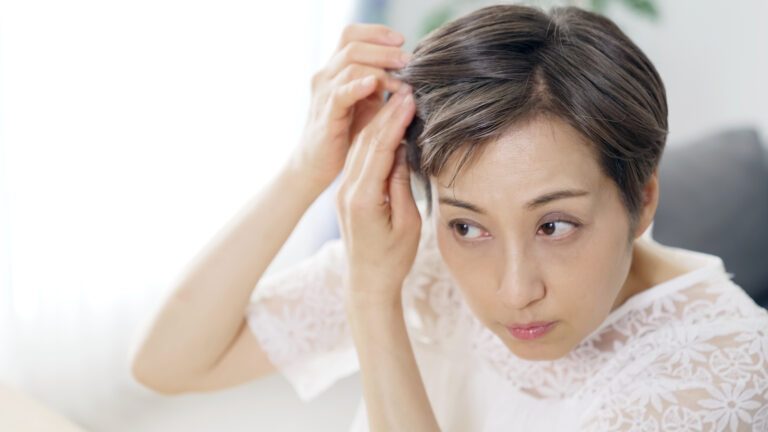 9 mejores productos de Minoxidil para la pérdida del pelo de Women's (2024) 8 Mujer comprobando la caída de su cabello
