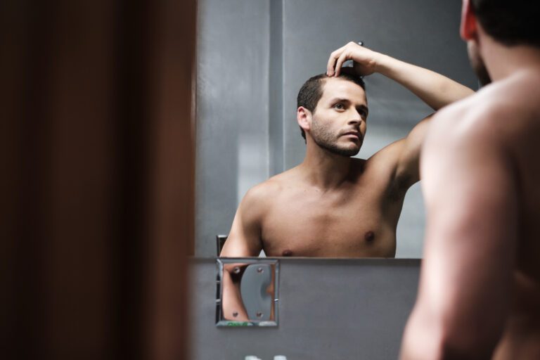 Oral Minoxidil For Hair Loss: This Is What You Need To Know 8 Man looking at his hair in the mirror