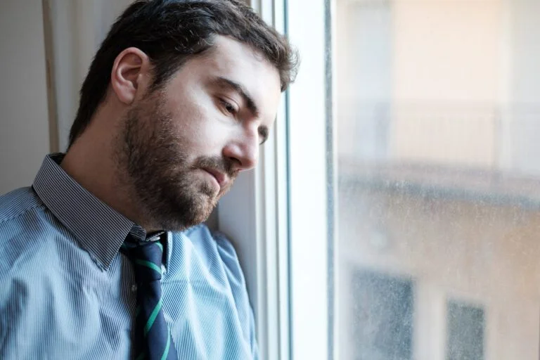 Homme triste regardant par la fenêtre