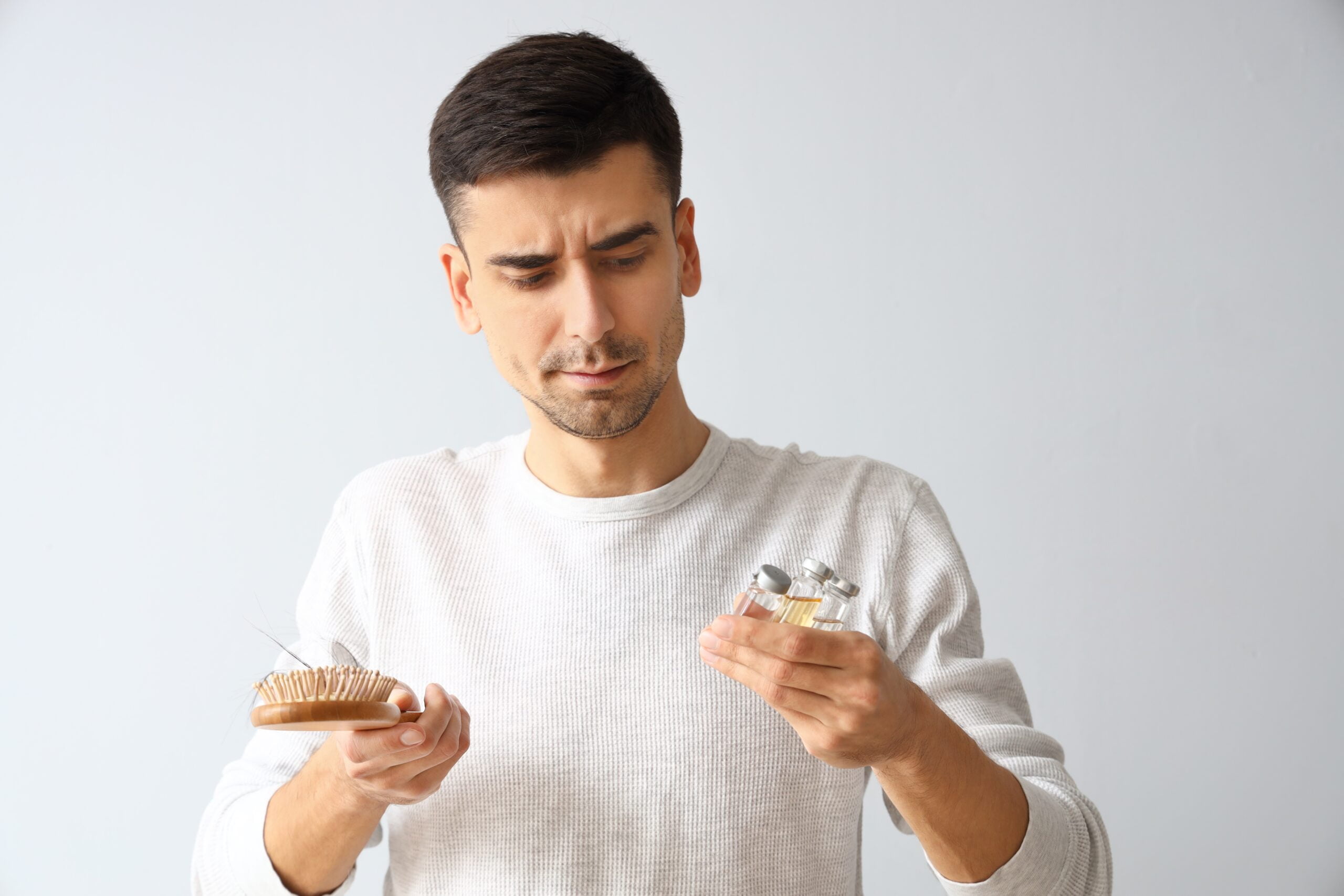 Kapan Waktu Terbaik Untuk Mulai Mengonsumsi Finasteride? 1 Seorang pria memegang sikat rambut dan obat-obatan