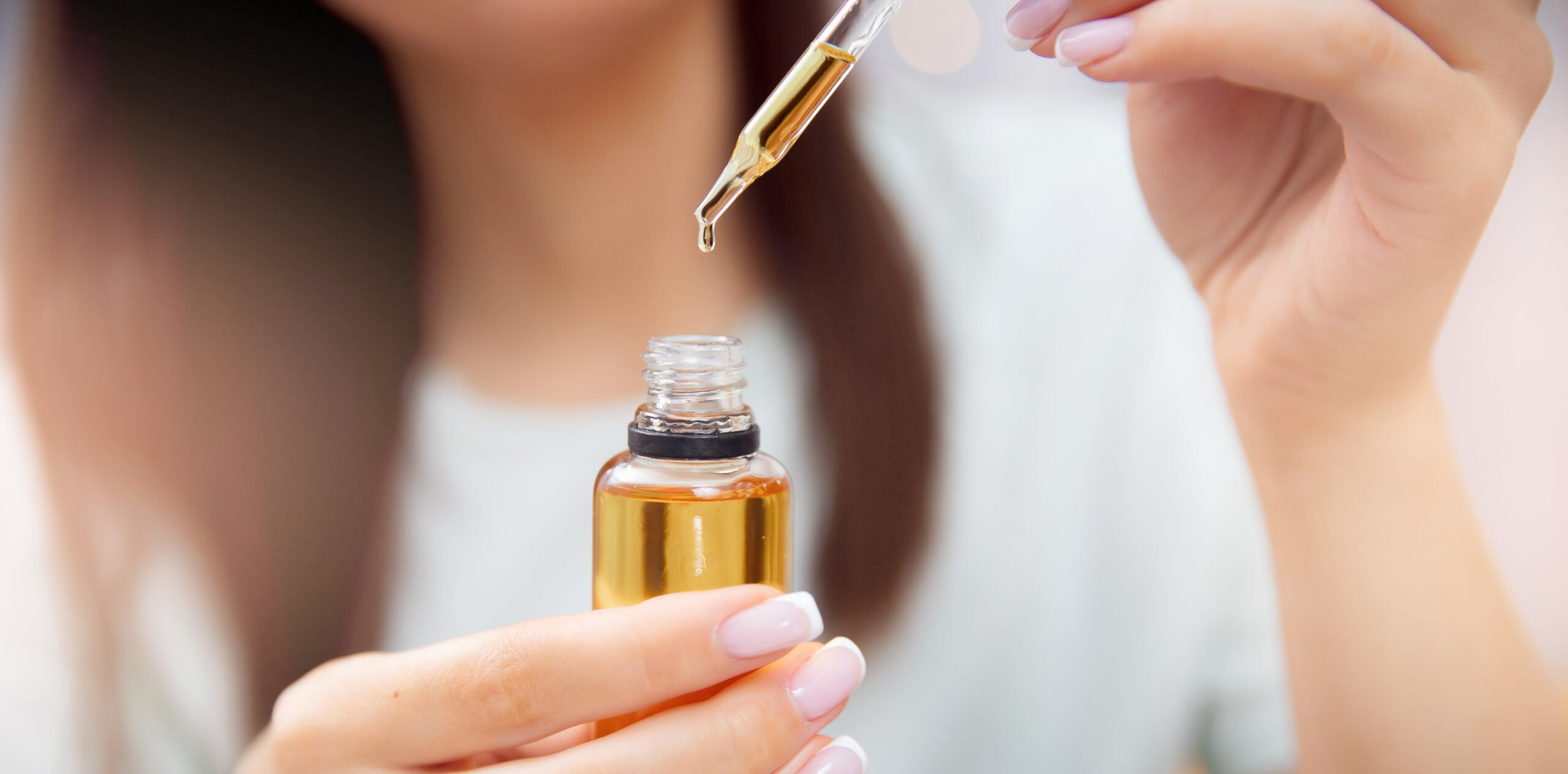 Cómo aplicar eficazmente el minoxidil en todo tipo de cabellos 1 Mujer sosteniendo una solución tópica contra la caída del cabello