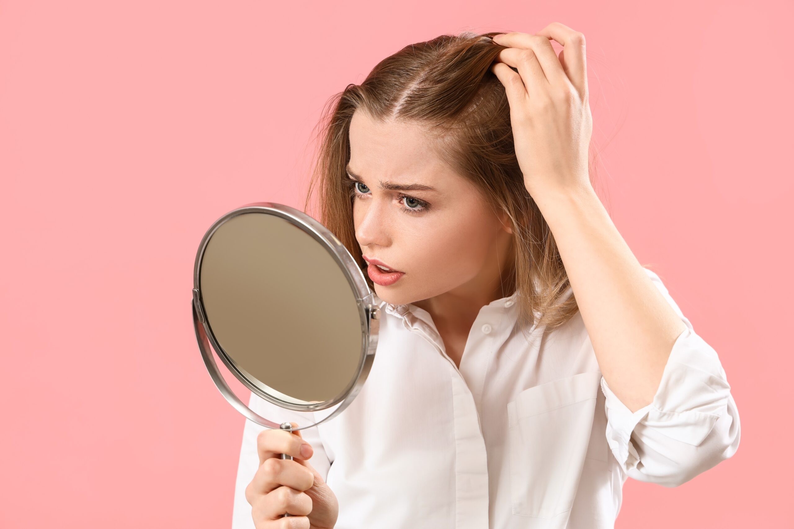 Ist stärkeres Minoxidil (10-15 %) besser gegen Haarausfall? 1 Frau inspiziert besorgt ihr Haar